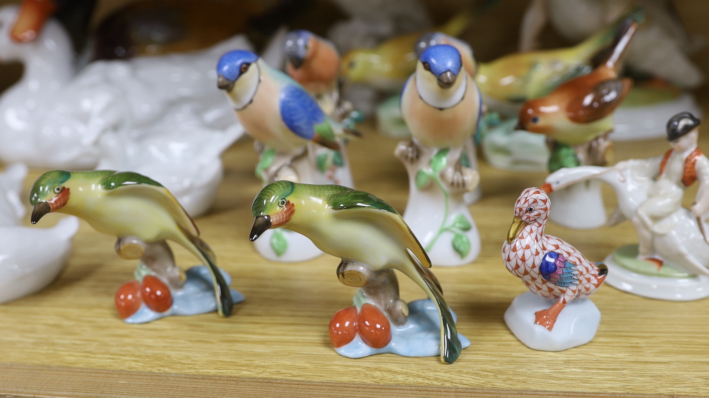 Seventeen Herend porcelain bird figures including boy riding a goose and ducks, some with hand painted decoration, the largest 30cm wide